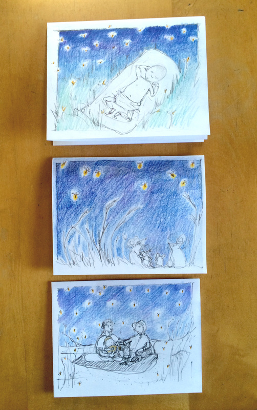 Photo of sketches of three cards featuring fireflies.  One is of a couple at the beach with their baby.  One features field mice watching fireflies.  The third is of a little baby sleeping on a blanket in the grass, among fireflies and golden flowers.